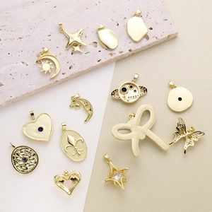Flat lay of vintage gold-plated star, moon and evil eye pendants with zircon stones