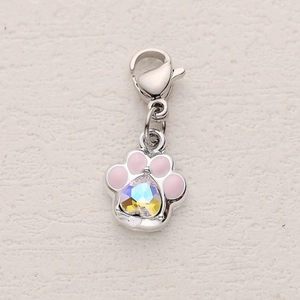Detail of silver cat paw charm with pink enamel and iridescent heart-shaped gemstone