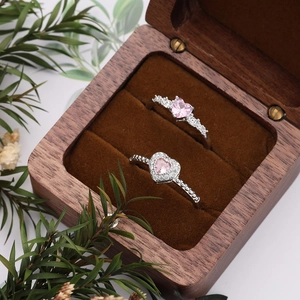 Detail view of pink heart zircon rings with bead texture in a wooden jewelry box