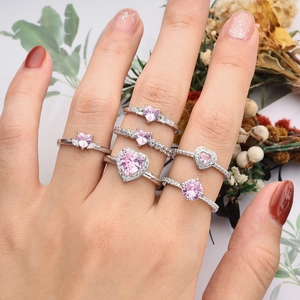 Adjustable pink heart zircon ring set in silver finish on hand with floral accents