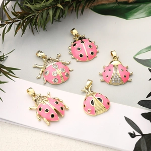 Detailansicht der pinkfarbenen Marienkäfer-Anhänger mit Goldauflage und Zirkonia