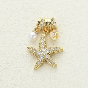 Detailed view of starfish pendant with 18K gold plating, cubic zirconia, and pearls