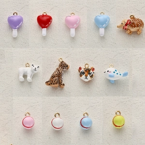 Detailed array of assorted colorful enamel animal and candy charms with metal loops