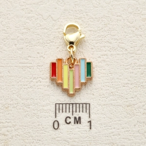 Rainbow striped heart pendant in gold alloy with lobster clasp on a textured background