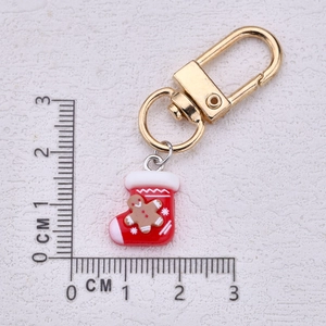 Christmas stocking keychain with gingerbread man charm and golden plating on white board