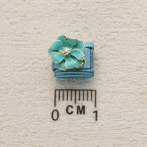 Detail view of 1cm blue metal charm link with teal enamel flower for DIY bracelets