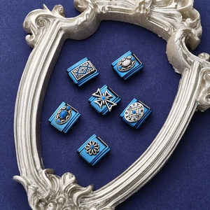 Close-up of vintage deep blue Italian modular charms with embossed silver patterns