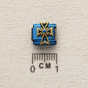 Macro view of blue stainless steel modular charm with golden Maltese cross and blue bead
