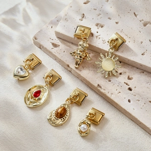 Charm italiani vintage in oro con motivi a sole e cuore su pietra travertino