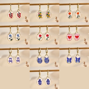 Vintage oval earrings set with flower cat and heart patterns on gold hoops