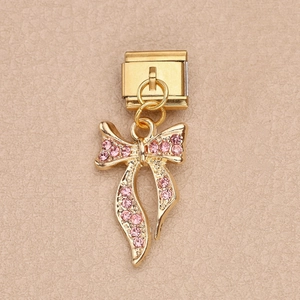 Charm italiano dorado con colgante de lazo en diamantes rosados sobre fondo cuero
