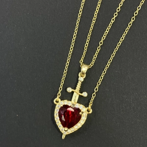 Luxuriöse goldene Herz-Halskette mit rotem Zirkon und Schwert-Design auf schwarzem Grund