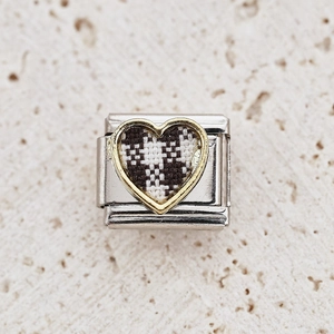 Macro detail of Italian charm link featuring gold heart with black and white checkered pattern