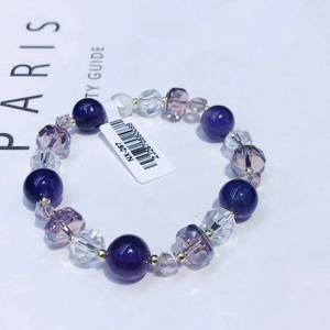 Elegant beaded amethyst bracelet with purple and gold beads on a Paris themed background