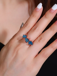 Blue apatite raw stone ring in 18K rose gold plating worn on a hand model