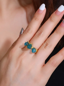 Detail of 18K rose gold plated ring with three raw blue apatite gemstones on hand