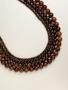 Macro view of multi-layered rosewood beads in varying sizes and natural wood textures