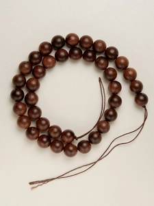 Macro detail of natural rosewood round beads showing smooth matte texture and wood grain