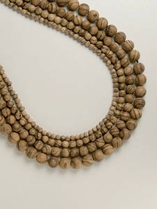 Detailed view of layered Vietnamese agarwood beads showing natural wood grain and textures