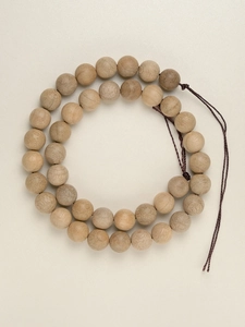 Detail of double-layer natural camphor wood beads showing authentic grain and texture
