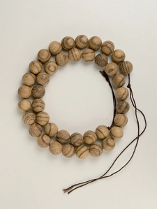 Detailed top view of double-layered Vietnamese agarwood beads showing natural wood grain