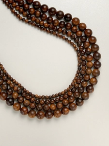 Macro shot of tiered round rosewood beads showing natural textures and deep brown tones