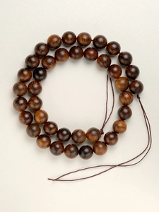 Macro shot of polished rosewood beads with natural dark grain for DIY jewelry