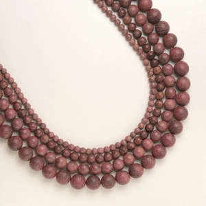 Perles en bois de santal brun rouge en quatre tailles disposées en rangées circulaires