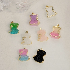 Pendentifs ours en cristal multicolores avec bordure dorée sur fond beige texture
