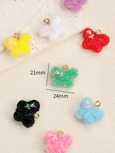 Détail macro de breloques papillon en résine de 21x24mm avec texture sucre et anneaux