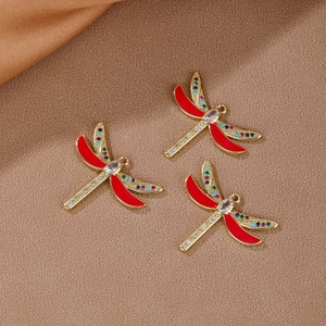 Three 18K gold-plated dragonfly pendants with red enamel wings and colorful cubic zirconia