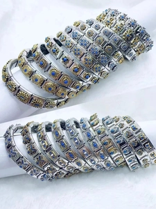 Detail showing modular Italian charm bracelets with floral relief and blue enamel inlay