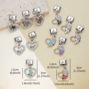 Makro-Detail der italienischen Herz-Charms mit Tulpen- und Schmetterling-Emaille