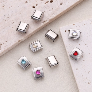 Italian charms in stainless steel with colorful heart crystals on stone background
