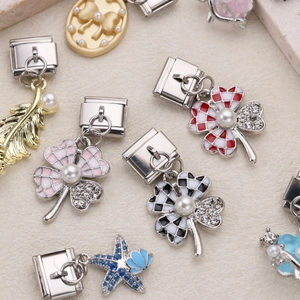 Italian charm bracelet links featuring clover, feather, and butterfly designs in stainless steel
