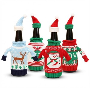 Detail of four knitted Christmas wine bottle covers with reindeer and snowman patterns
