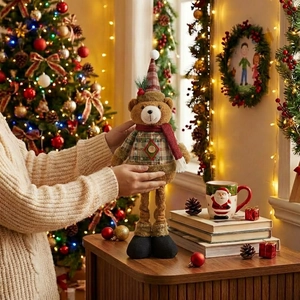 Detail of Christmas teddy bear plush with retractable legs and festive knit outfit