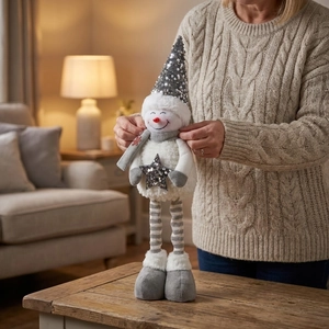 Macro shot of plush Christmas snowman doll with silver sequins and long striped legs