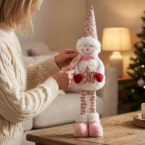 Detailed close-up of a plush pink sequin snowman doll with a cozy holiday scarf