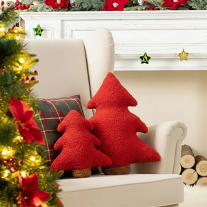 Detailed view of red Christmas tree pillows in plush texture on a cozy cream sofa