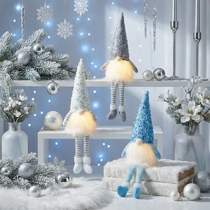 Close-up of three glowing Christmas gnomes with sequined hats and long striped legs