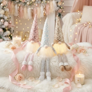 Three glowing Christmas gnomes with sequins and long striped legs in cozy festive scene