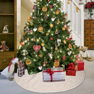 Détail du tapis de sapin de Noël en tricot torsadé crème avec décorations