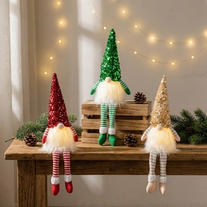 Three glowing Christmas gnomes with sequin hats and warm LED lights on wood table