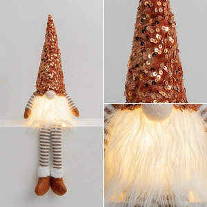 Macro details of glowing Christmas gnome with sequin hat and soft hanging striped legs