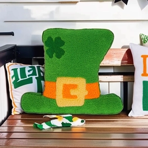 Saint Patrick's Day green hat throw pillow with clover pattern on a wooden chair