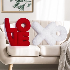 Close-up of LOVE and XO letter shaped decorative pillows in red and white sherpa fabric