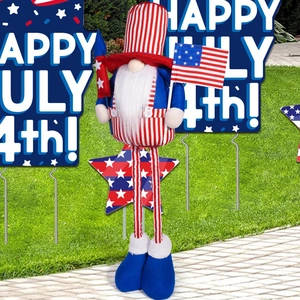 Detail of Fourth of July gnome with USA flag standing on a sunny garden lawn