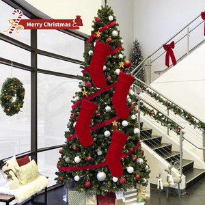 Close-up of four red cable knit Christmas stockings hanging on a tree as festive decor