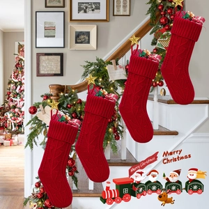 Close-up of four red knitted Christmas stockings with gold stars on indoor stairs
